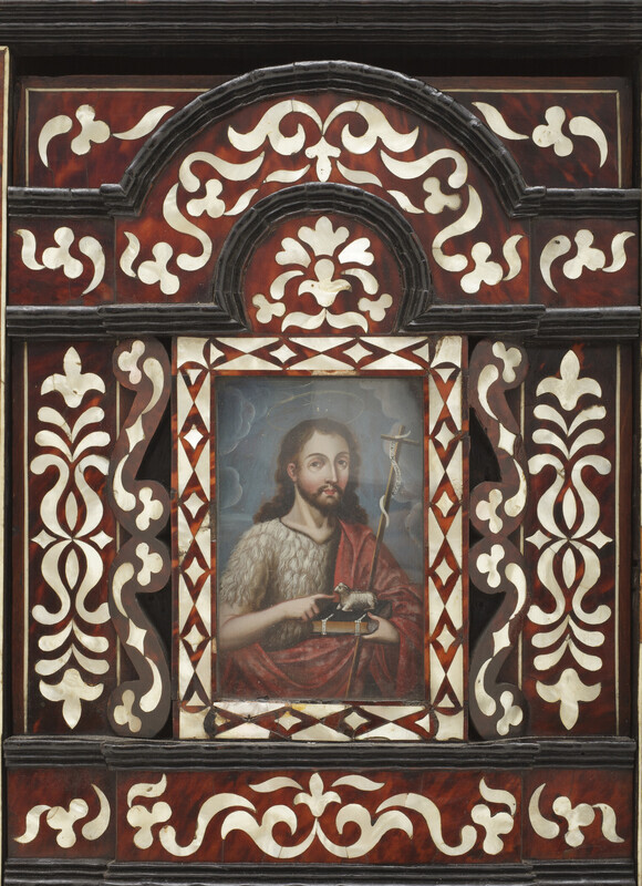 Detail of front panel with a painting of a bearded man with long brown hair wearing a gray hair shirt and a red tunic. The man has a halo, carries a crucifix, a bible, and a sheep figurine. The object is photographed on a white background. 