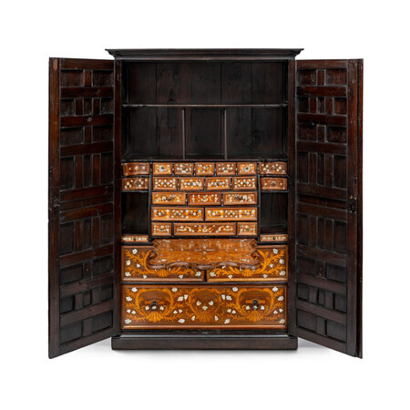 Open rectagular cabinet made from a dark wood with lighter wood inlay accented with mother of pearl. The top of the cabinet is open with many small drawers above the fall-front desk and three drawers underneath. Photographed on a white background.