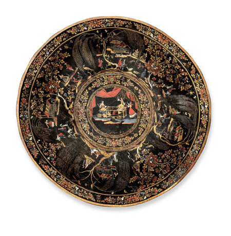 Multi-colored circular tray in imitation-lacquered wood viewed from above. It includes a central medallion with the Greek myth of Arachne and Athena, surrounded by vignettes of regional daily life all on a black background with gold inlay. Object is photographed on a white background. 